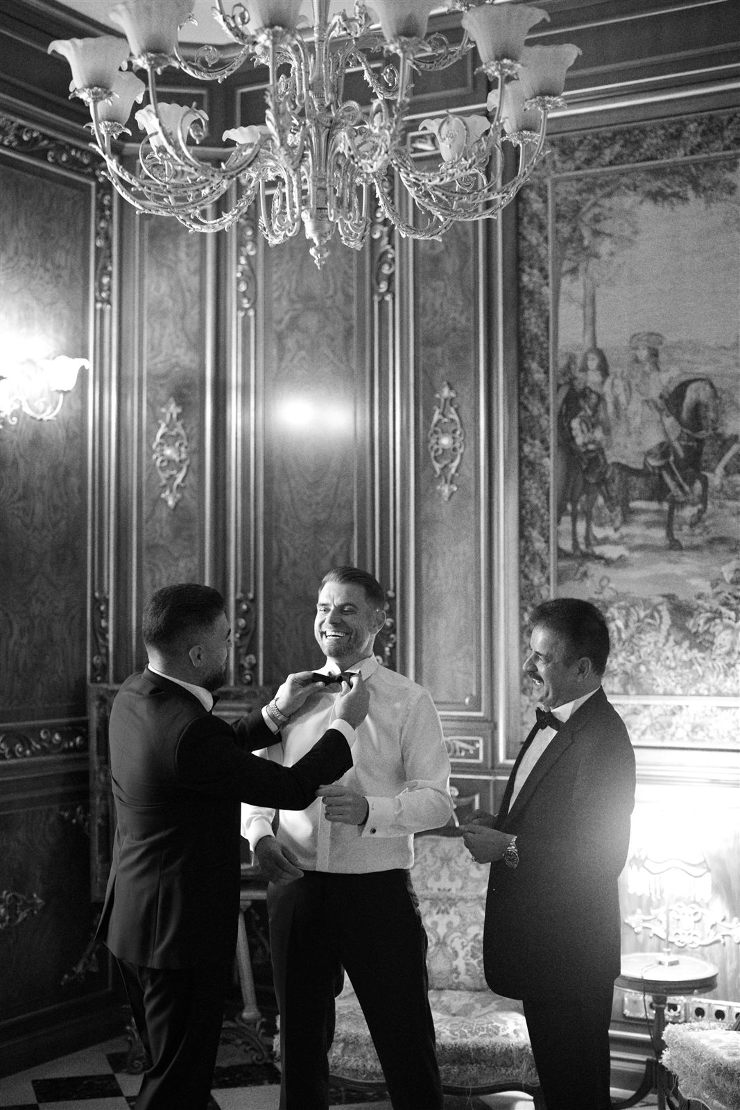 Aranjatul papionului la o ținută black tie, cadru alb-negru sub candelabru, la Palatul Noblesse