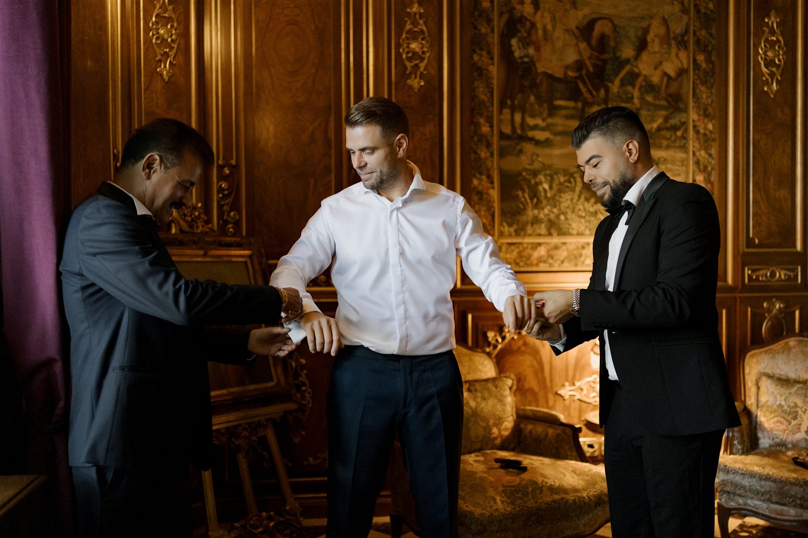 Pregătire black tie — cămașă albă și butoni, doi bărbați în smoking, într-un salon al Palatului Noblesse