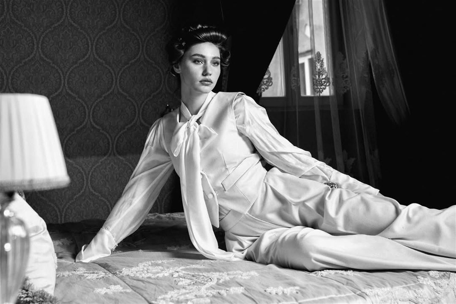 Rochie roșie de cocktail pe balconul unei clădiri istorice, ținută de zi elegantă