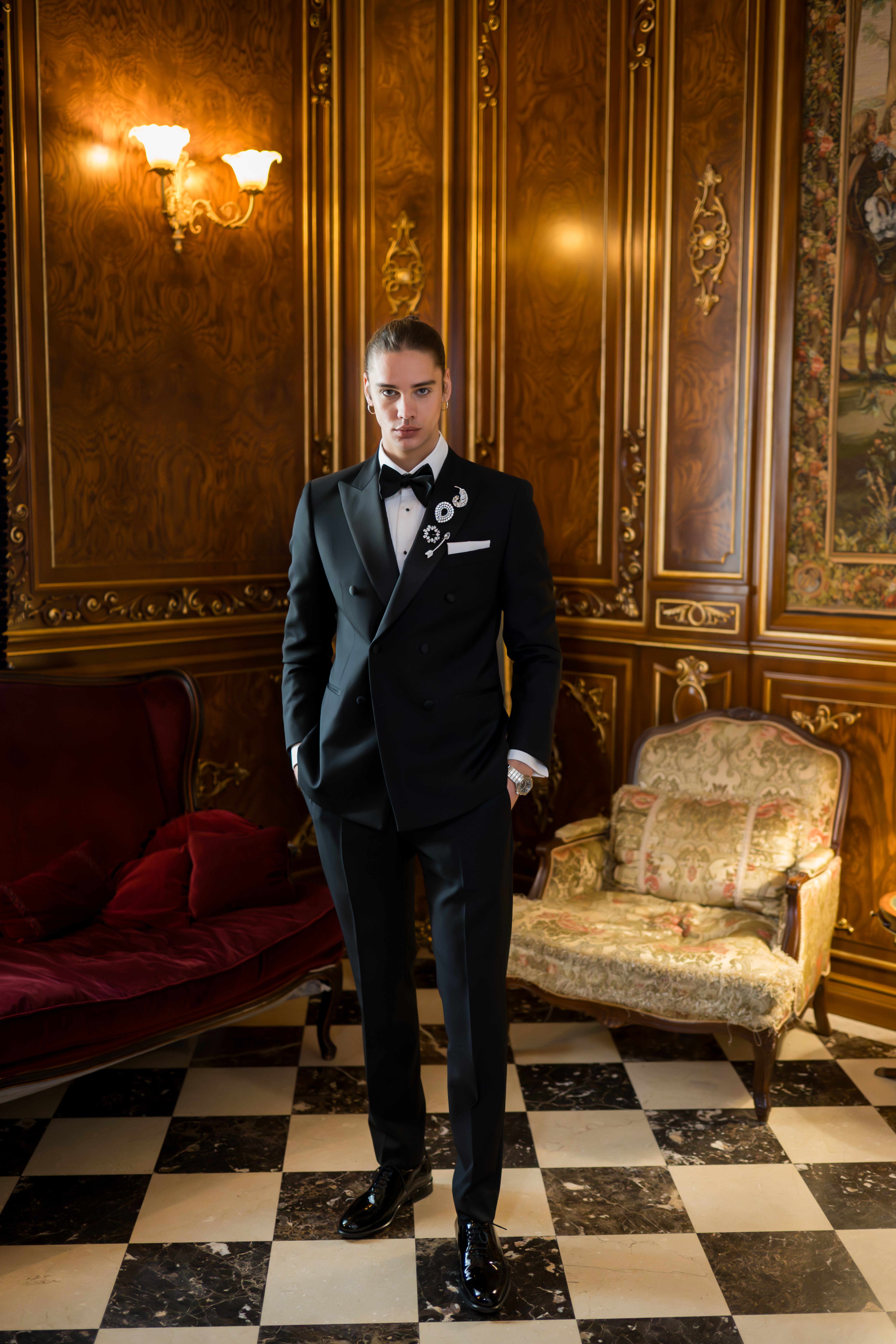 Model masculin în tuxedo dublu-butonat cu broșă — salon aurit Palatul Noblesse, tendinte mire 2026
