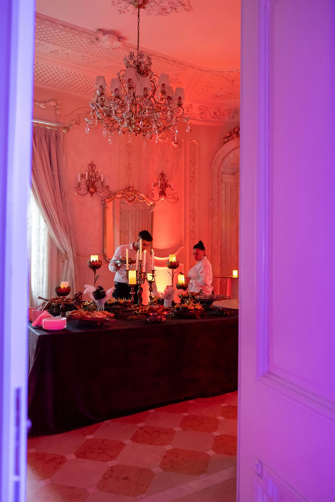Salon cu lumini de ambianță roșii și bufet decorat la o petrecere de majorat la Palatul Noblesse
