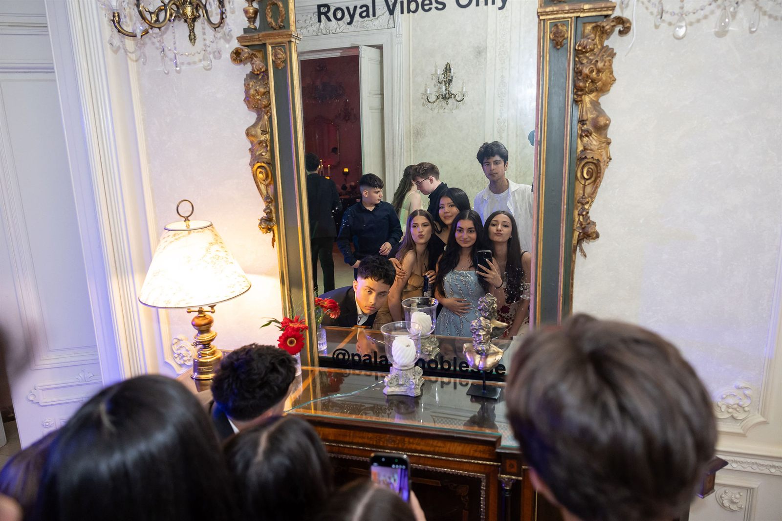 Adolescenți fac un selfie în oglinda cu mesaj Royal Vibes Only la un majorat la Palatul Noblesse