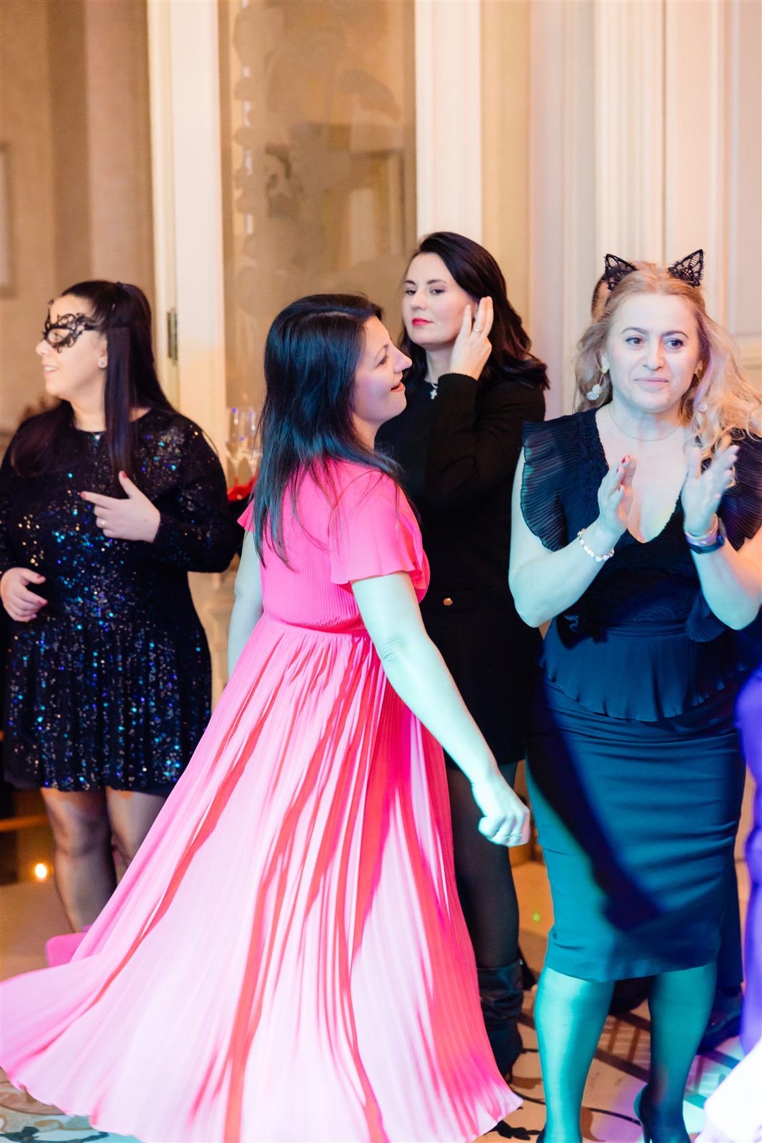 Invitată în rochie roz dansând la balul mascat
