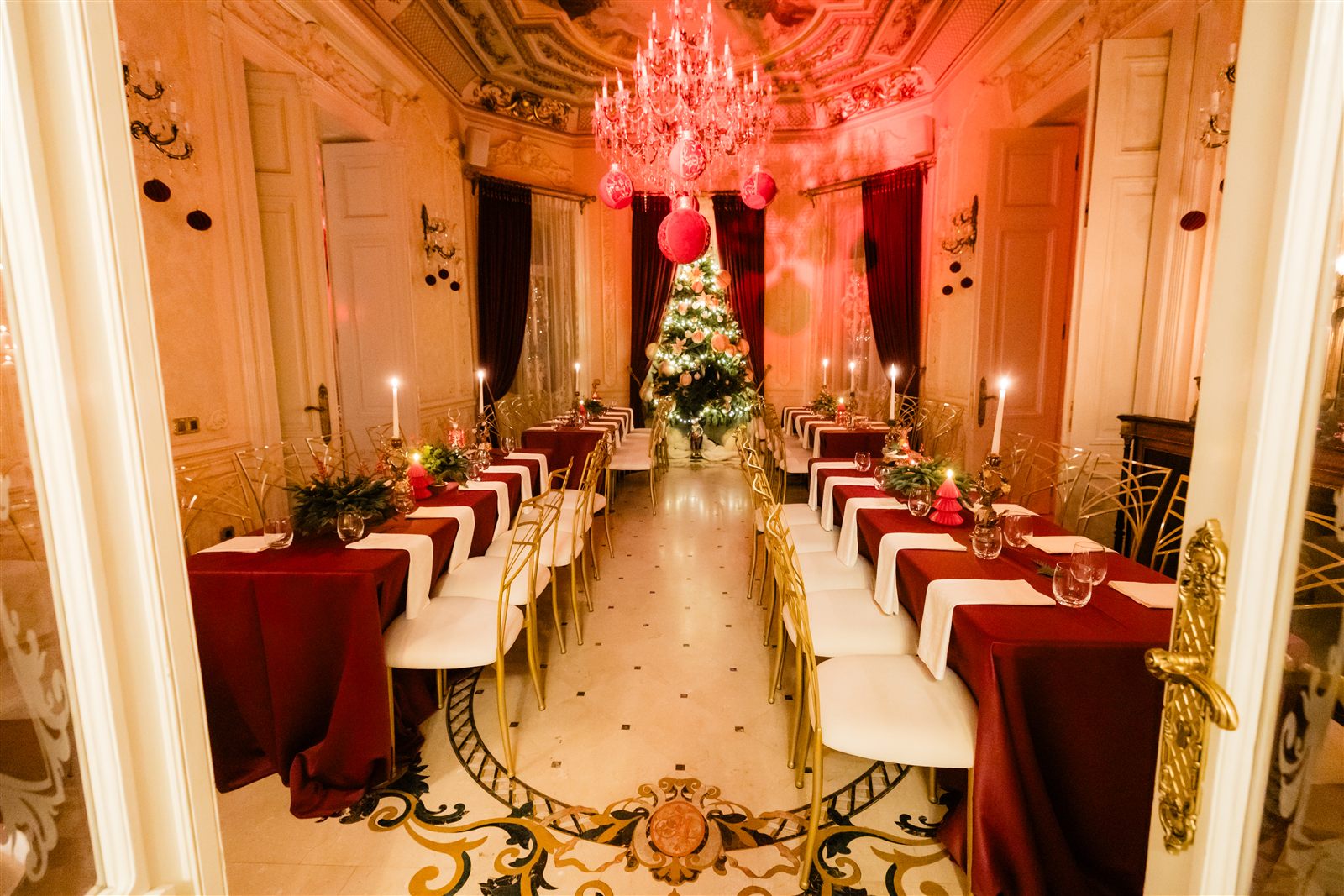 Salon cu mese imperiale și candelabru de cristal, pregătit pentru balul mascat de sfârșit de an