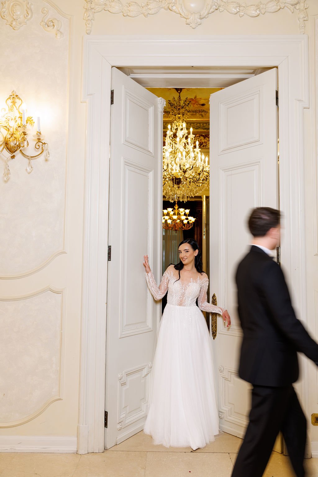 Ioana în pragul salonului cu candelabru auriu — sedință foto nuntă Palatul Noblesse București