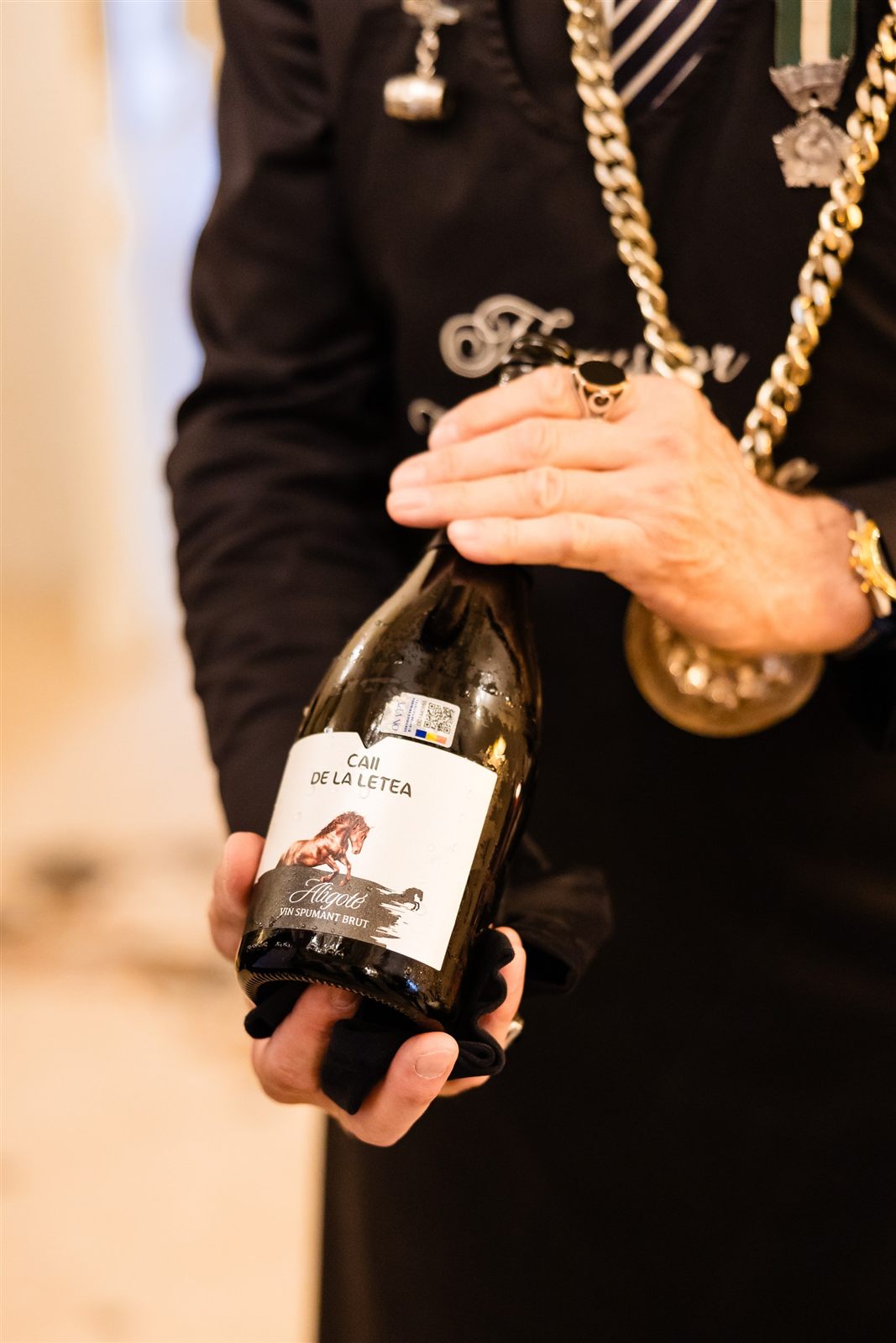Somelierul prezentând sticla de vin — experiența oenologică la Palatul Noblesse