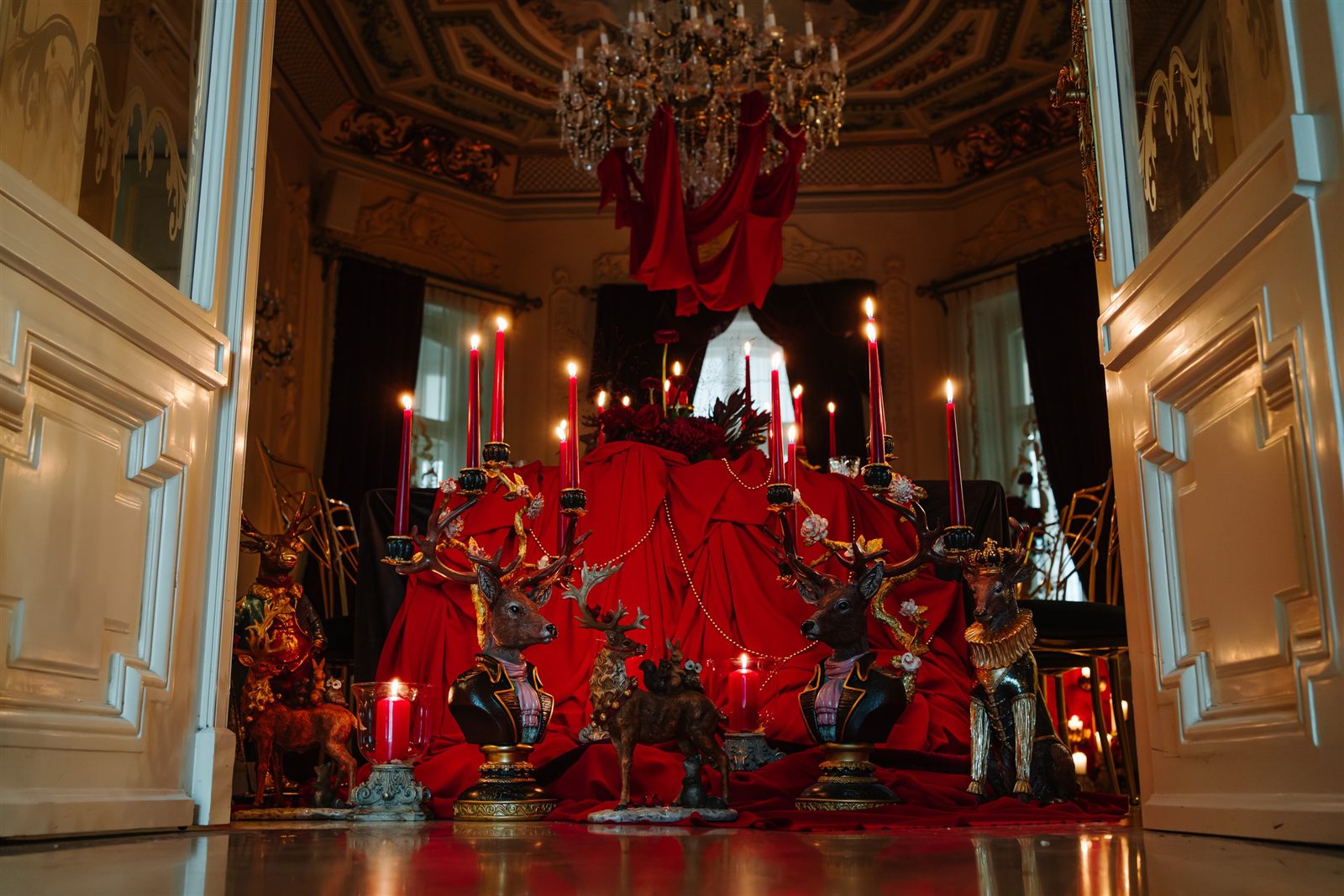 Catifea roșie drapată din candelabru și masă de gală în Salonul Baroque al Palatului Noblesse
