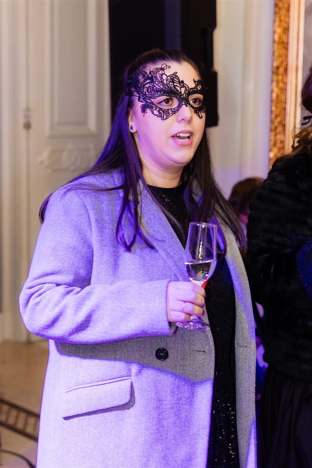 Invitată cu mască neagră și rochie de seară
