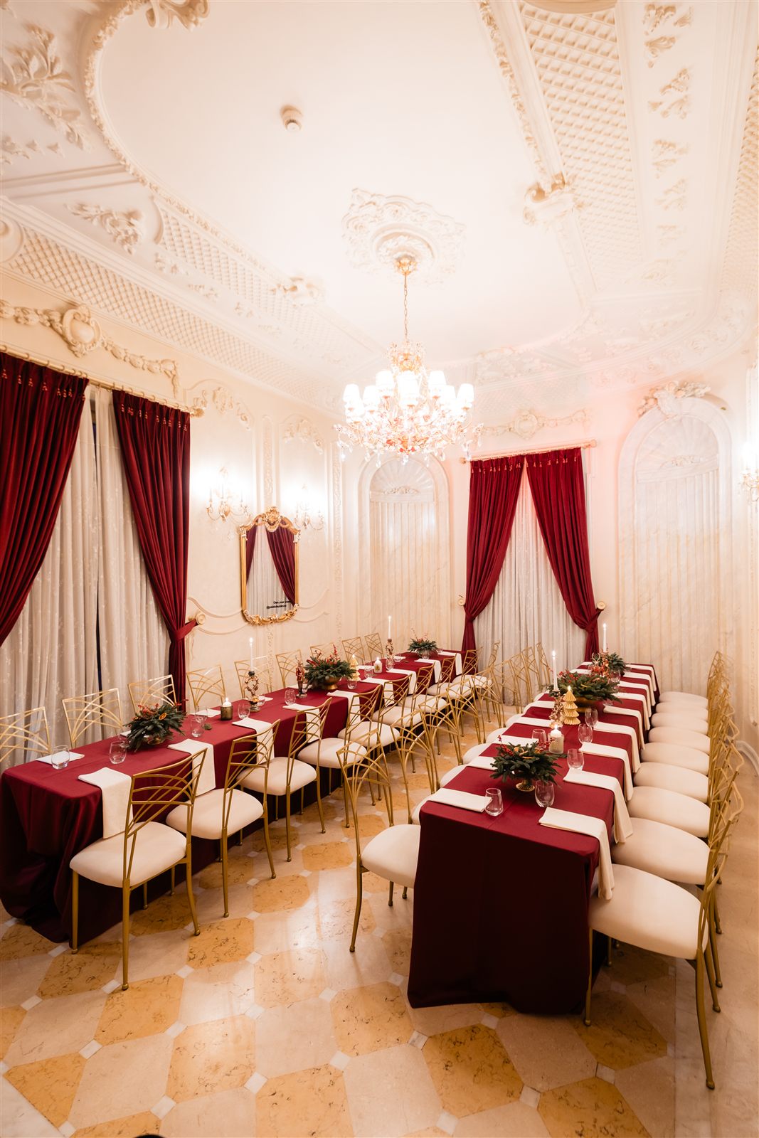 Salonul Florence amenajat festiv de Craciun cu mese rosii si candelabru la Palatul Noblesse
