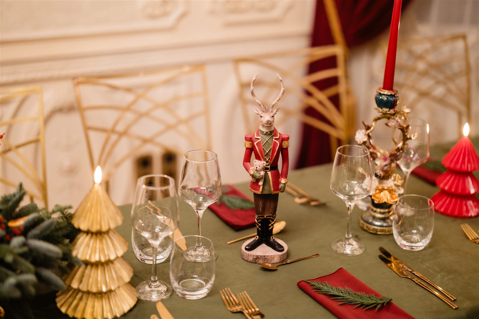 Masă festivă cu figurine de Crăciun și pahare de cristal