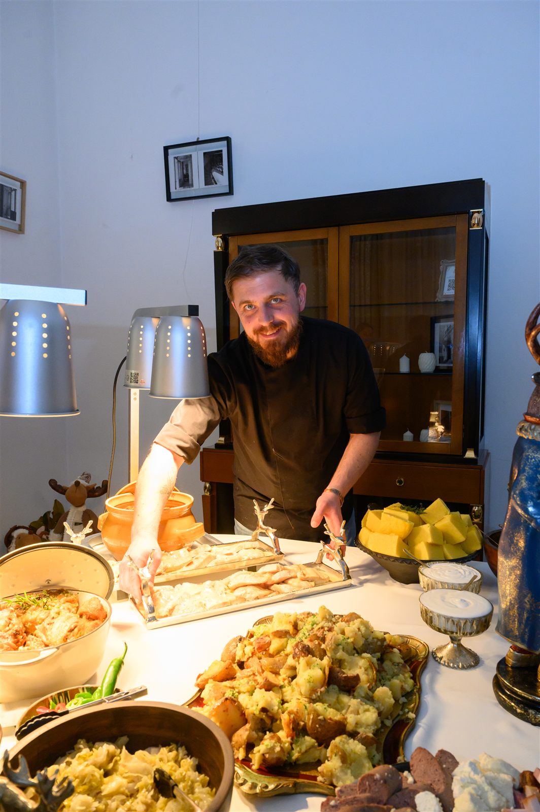 Chef porționând preparate calde pentru invitații petrecerii de Crăciun Dossier