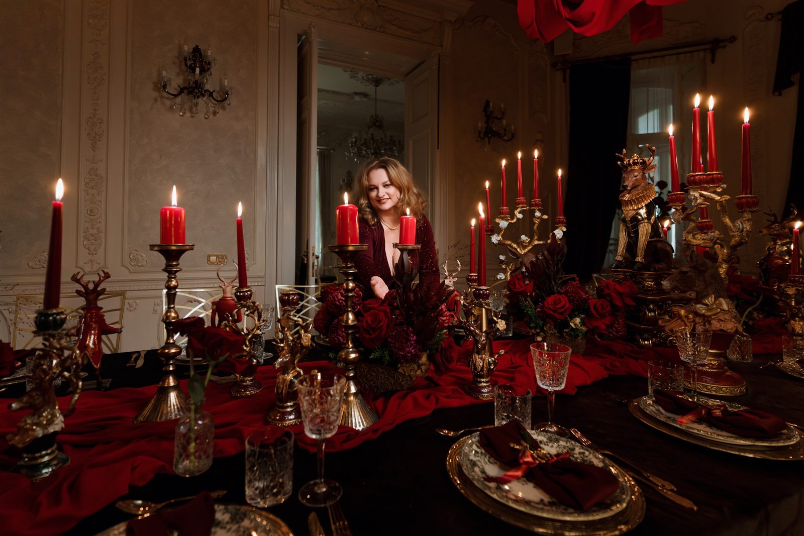 Gazda serii la masa Royal Christmas Dinner, printre sfeșnice aurii
