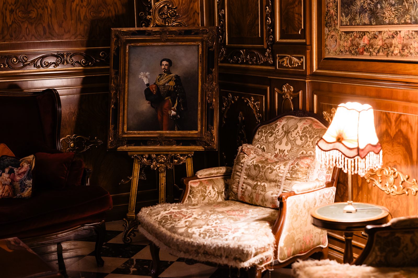 Colț din Salonul Regent cu portret de epocă, fotoliu Ludovic XV și lampă — atmosfera Cigar Experience