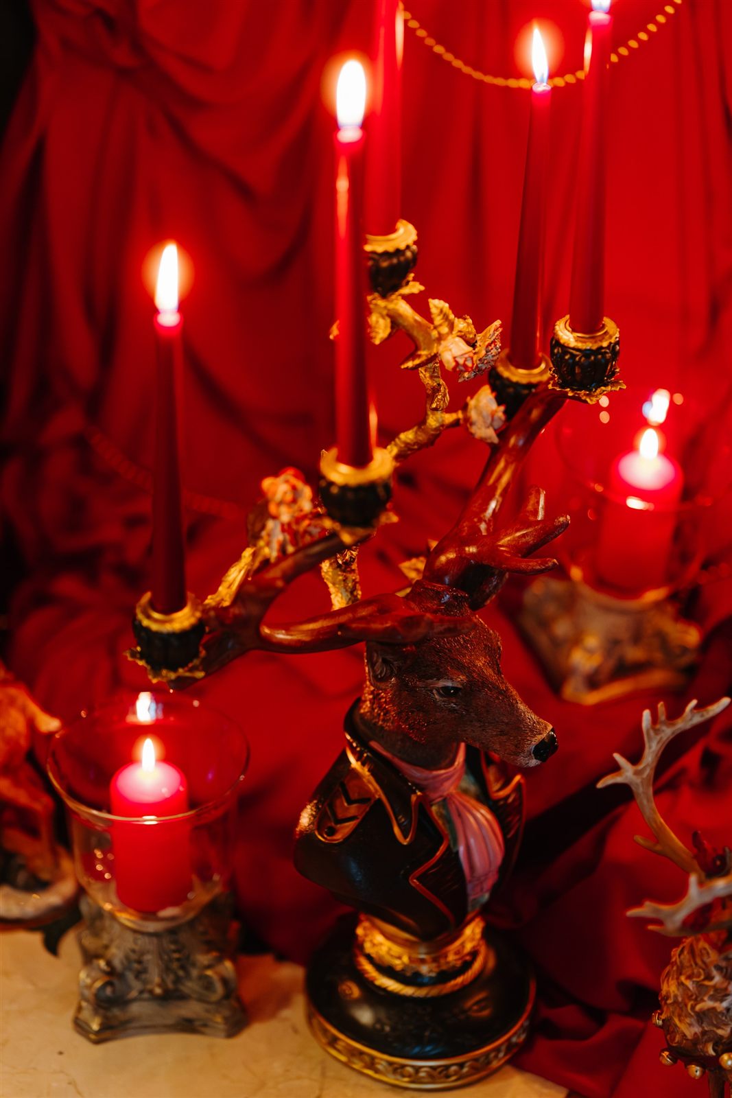 Sfeșnic auriu cu cerb și lumânări roșii, decor Royal Christmas Dinner