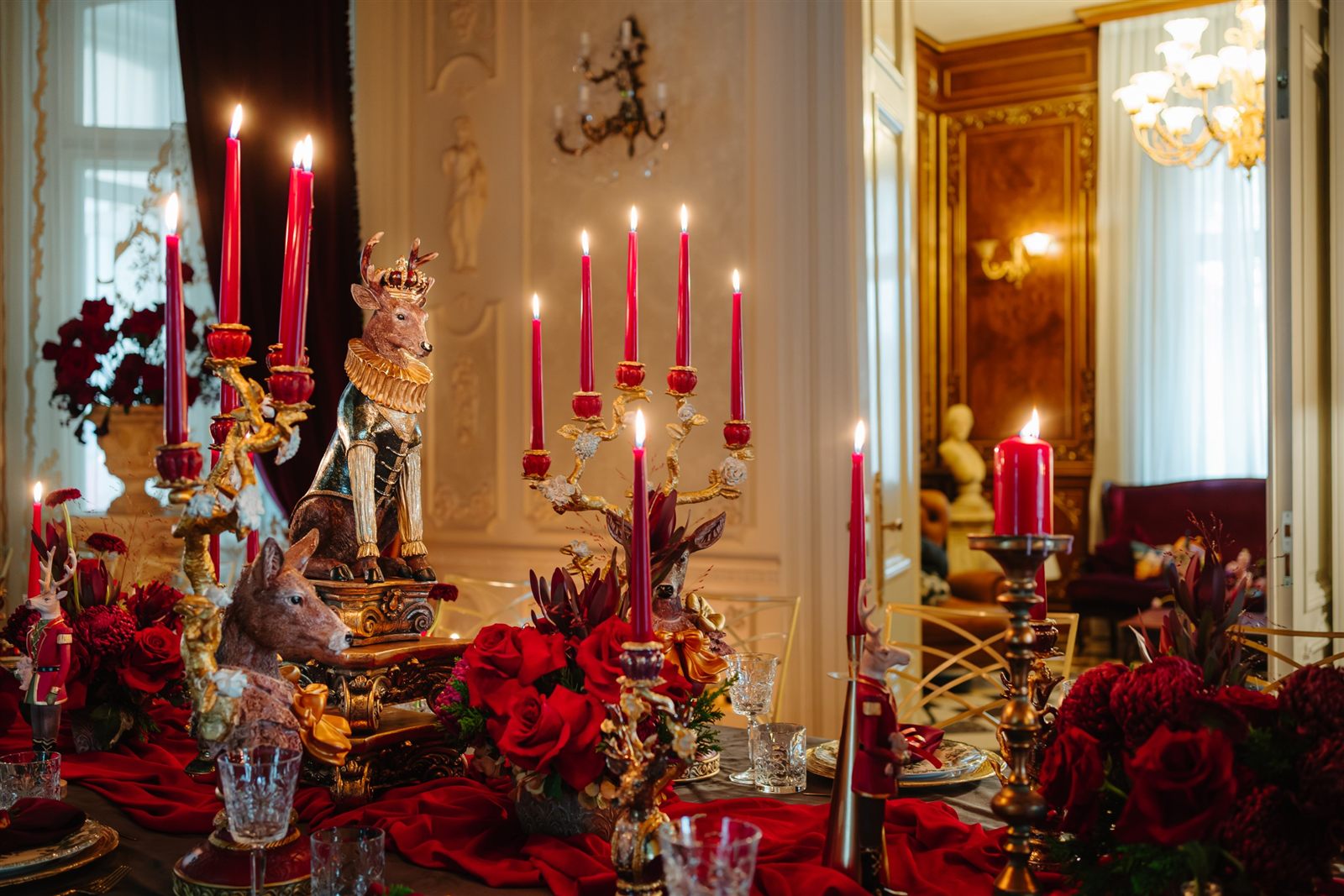 Sfeșnice aurii cu lumânări roșii și trandafiri burgundy, decor regal de Crăciun