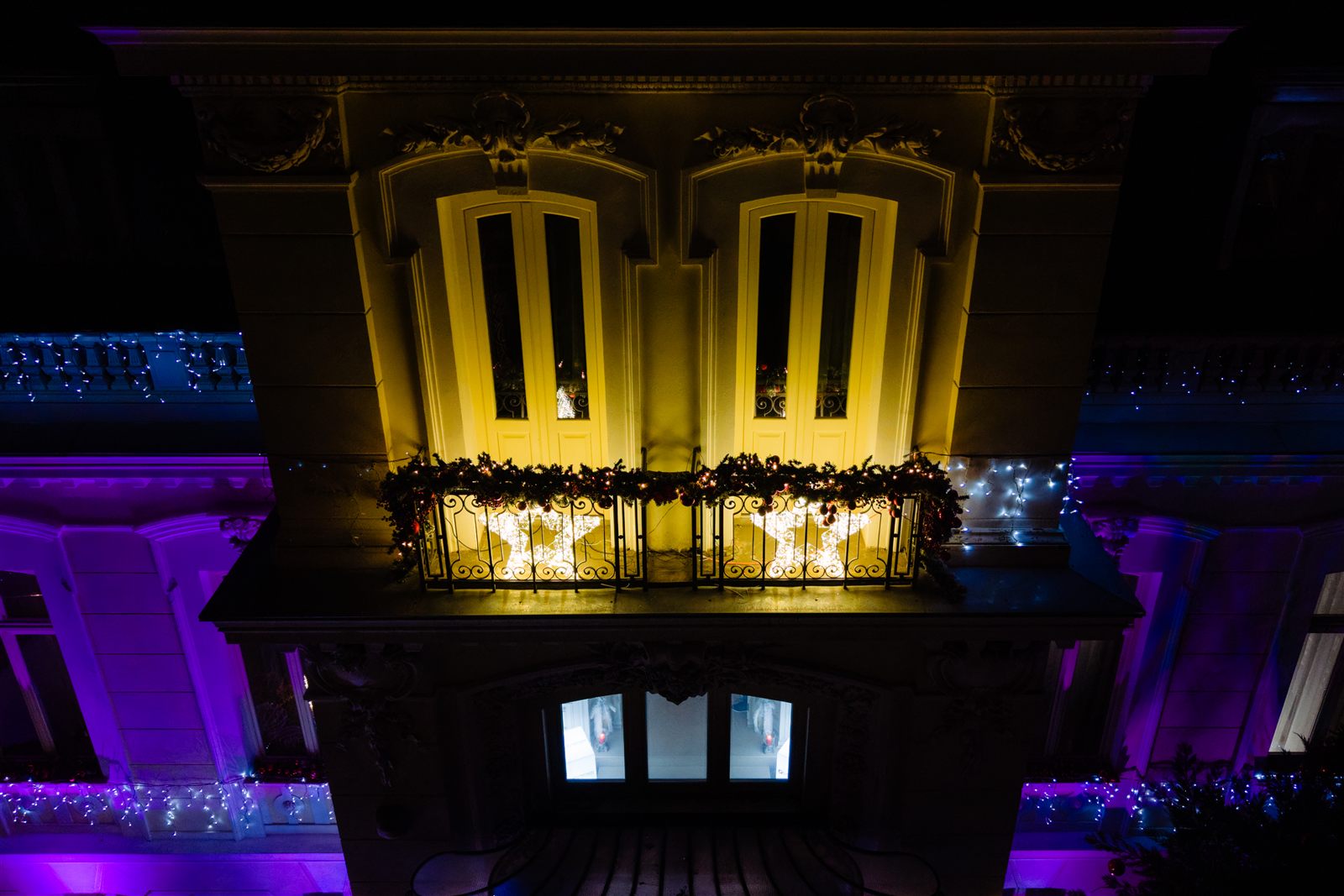 Balconul fațadei Palatului Noblesse luminat în culori de sărbătoare