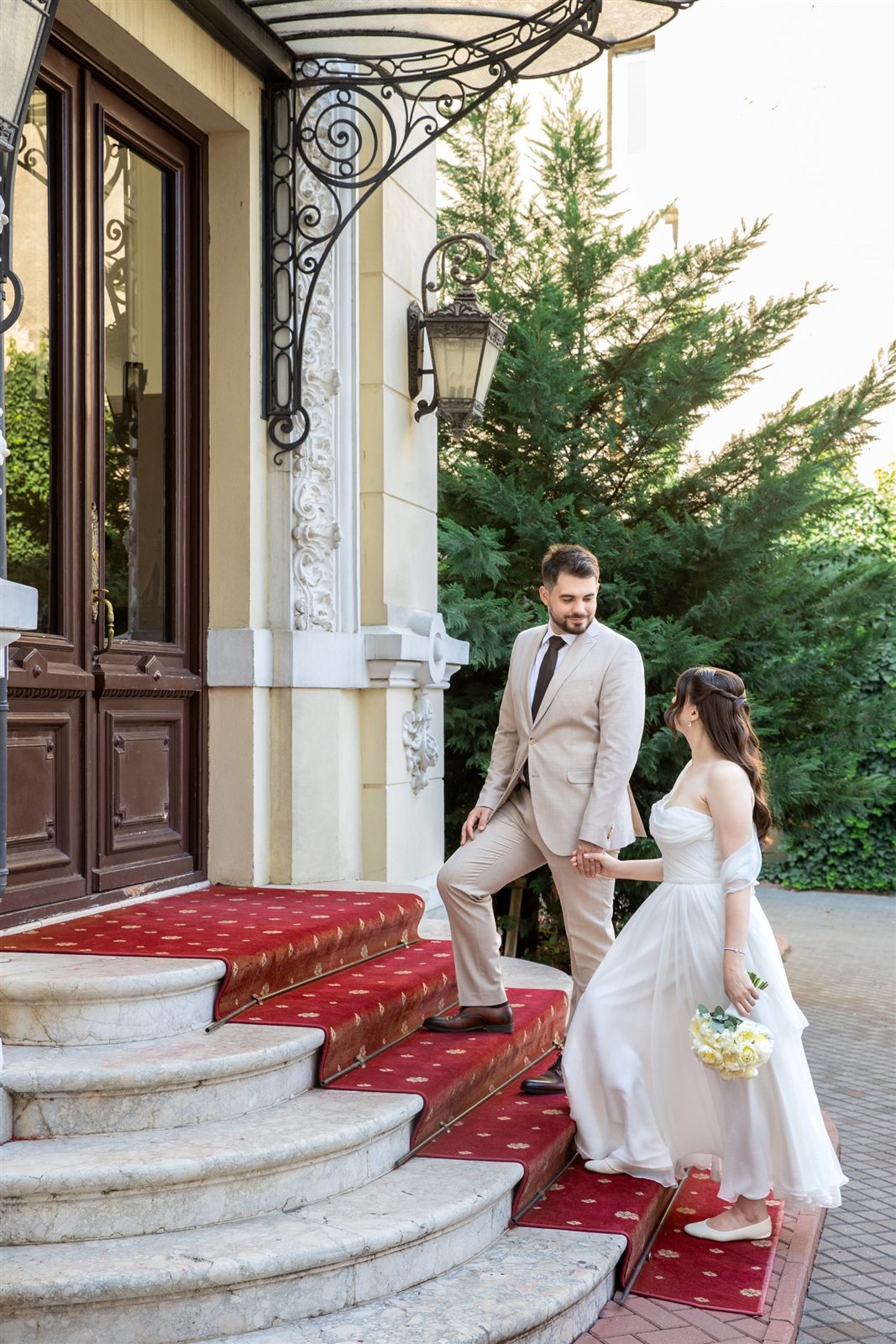 Miri pe scara de intrare cu covor roșu — cununie restrânsă la Palatul Noblesse