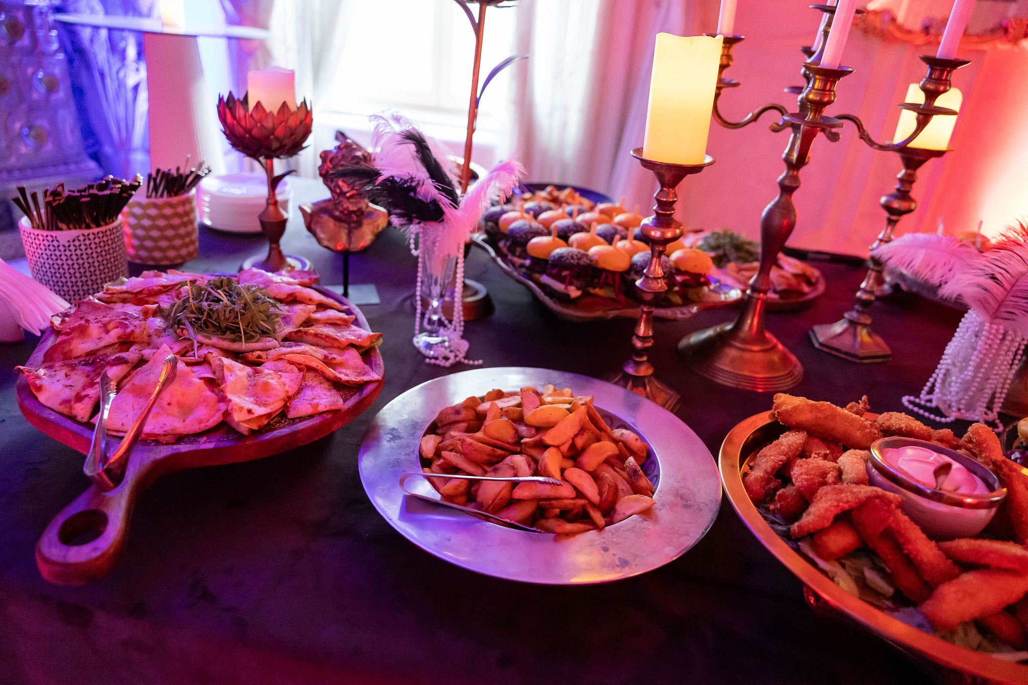 Detaliu masă buffet banchet — pizza, wedges, canapele, candelabru, lumina roz Palatul Noblesse