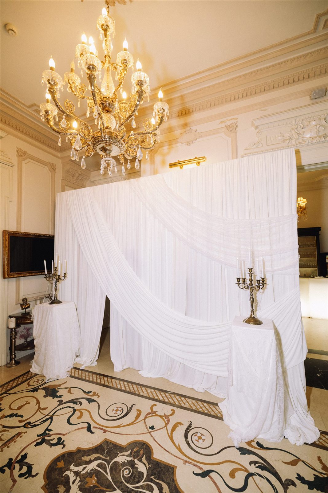 Backdrop alb cu candelabru de cristal pregătit pentru petrecerea burlăcițelor la Palatul Noblesse