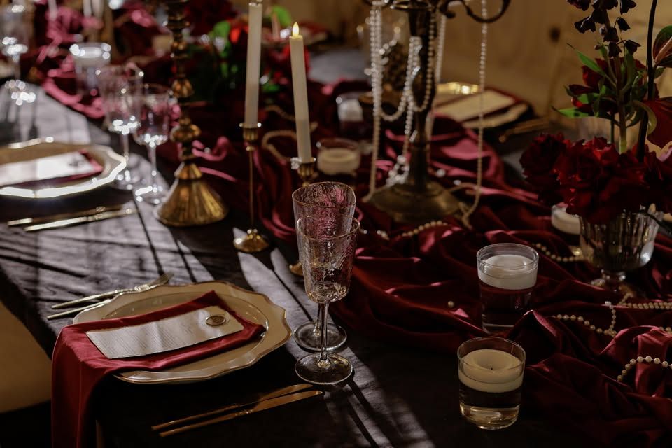 Masă regală roșie cu sfeșnice aurii și trandafiri — detaliu de decor la Palatul Noblesse