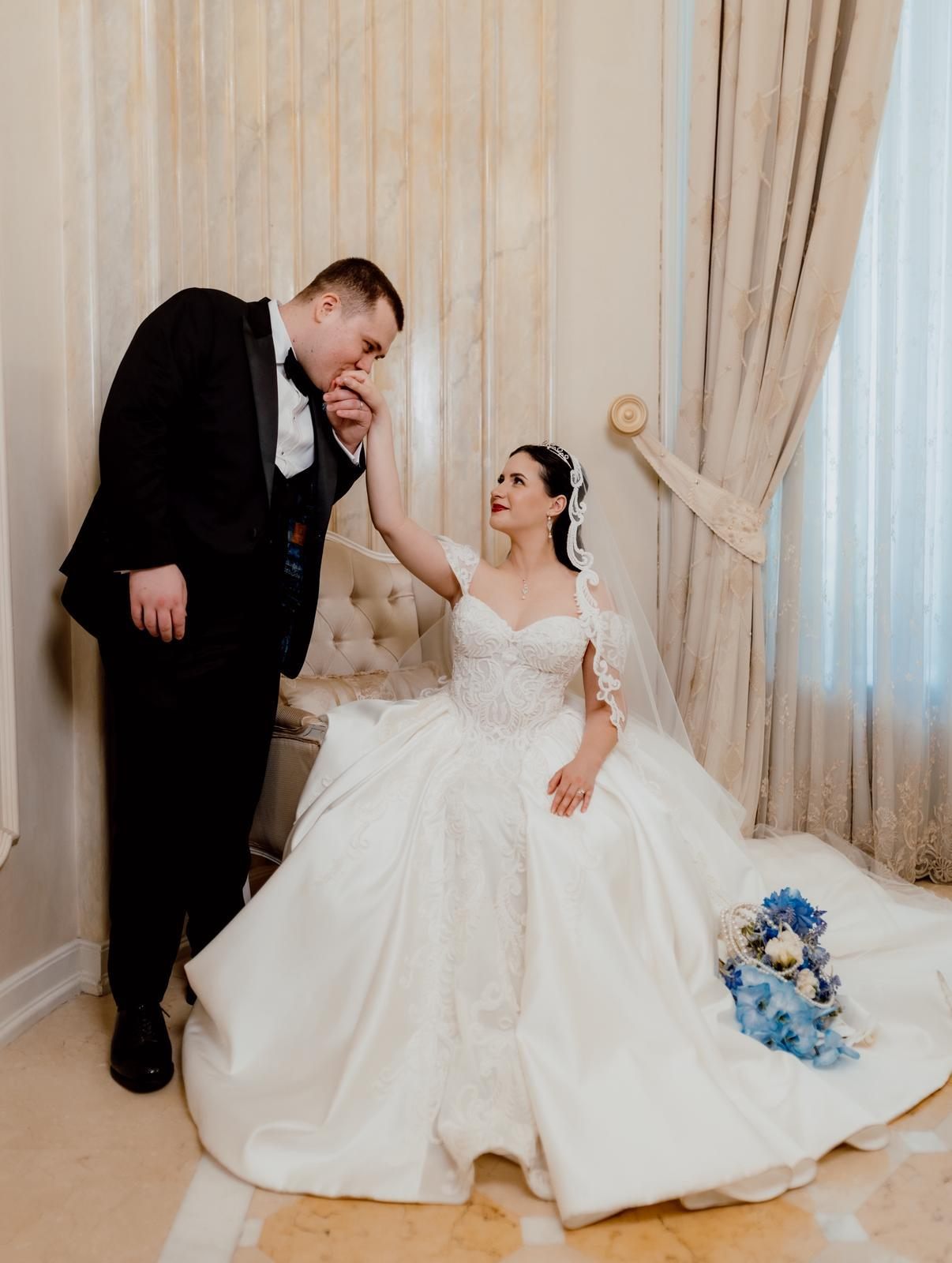 Mirele sărutând mâna miresei într-un salon al Palatului Noblesse