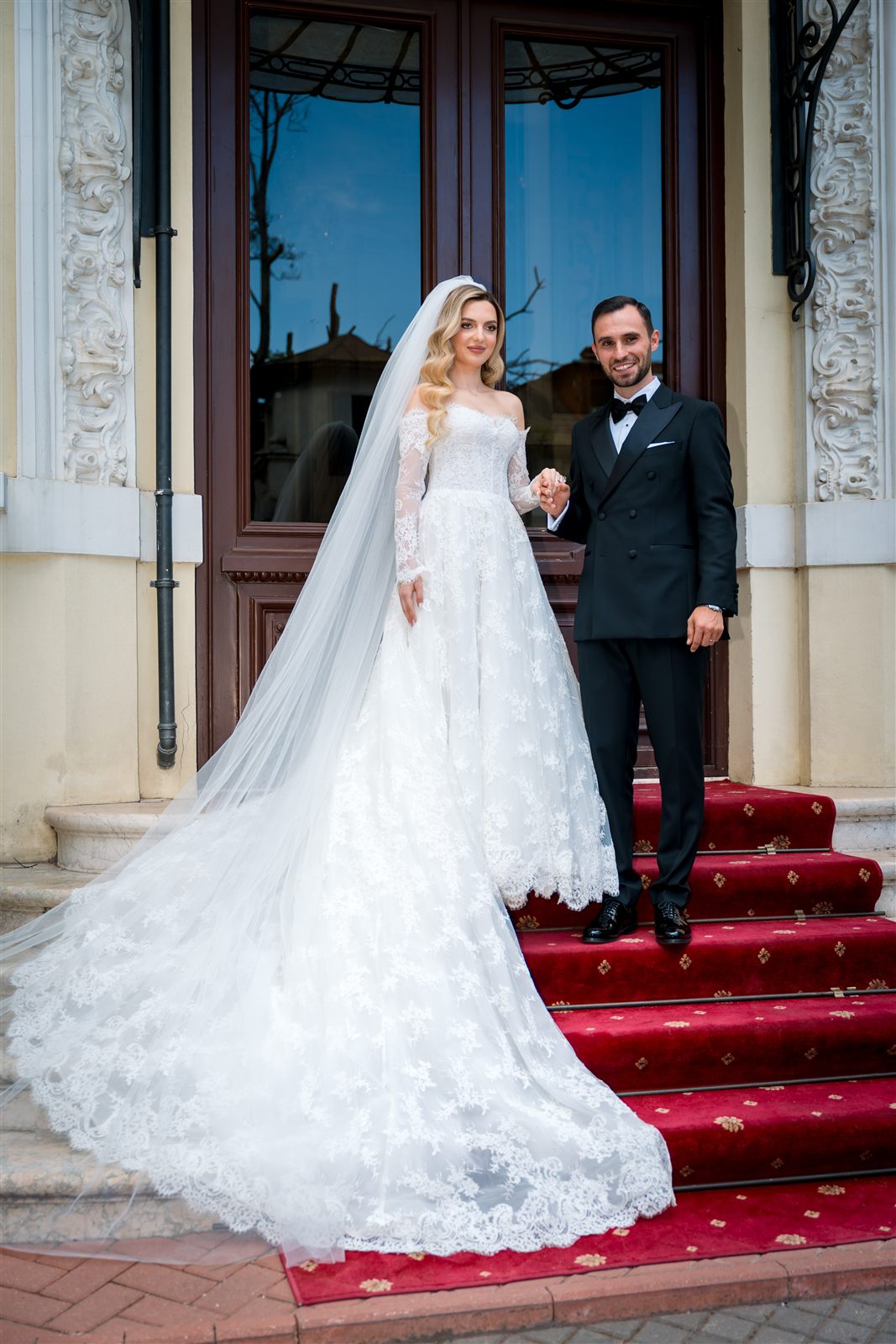 Miri pe scările cu covor roșu ale Palatului Noblesse — ședință foto de nuntă exterioară