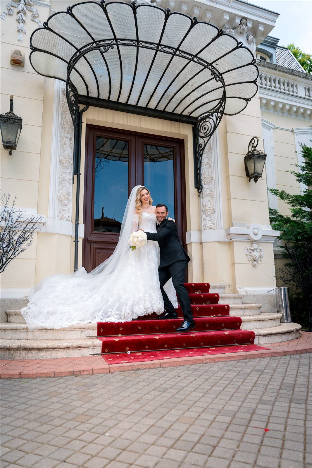 Miri pe scările cu covor roșu, la fațada Palatului Noblesse — ședință foto de nuntă