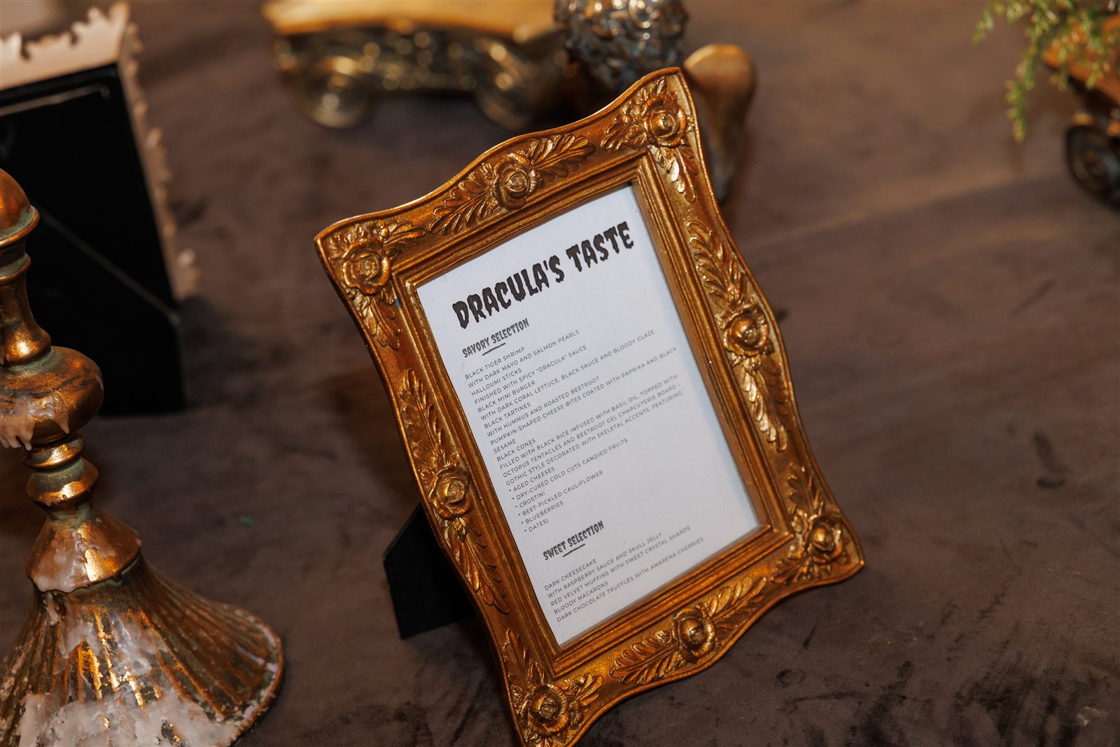 Afiș „Dracula's Palace" în ramă aurită la intrare — semnalistică tematică de eveniment