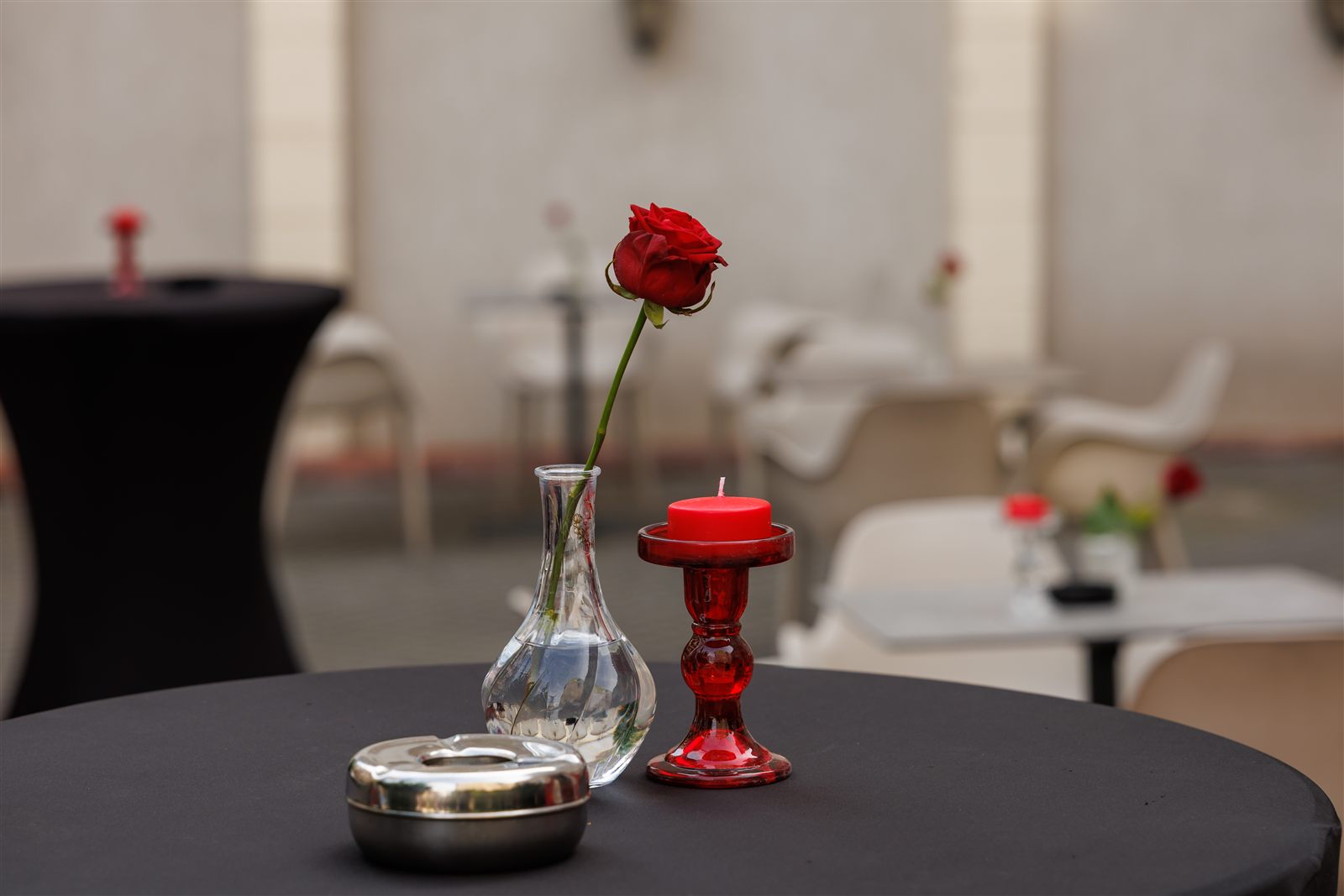 Trandafir roșu și cocktail pe masă neagră — detaliu de decor tematic Dracula