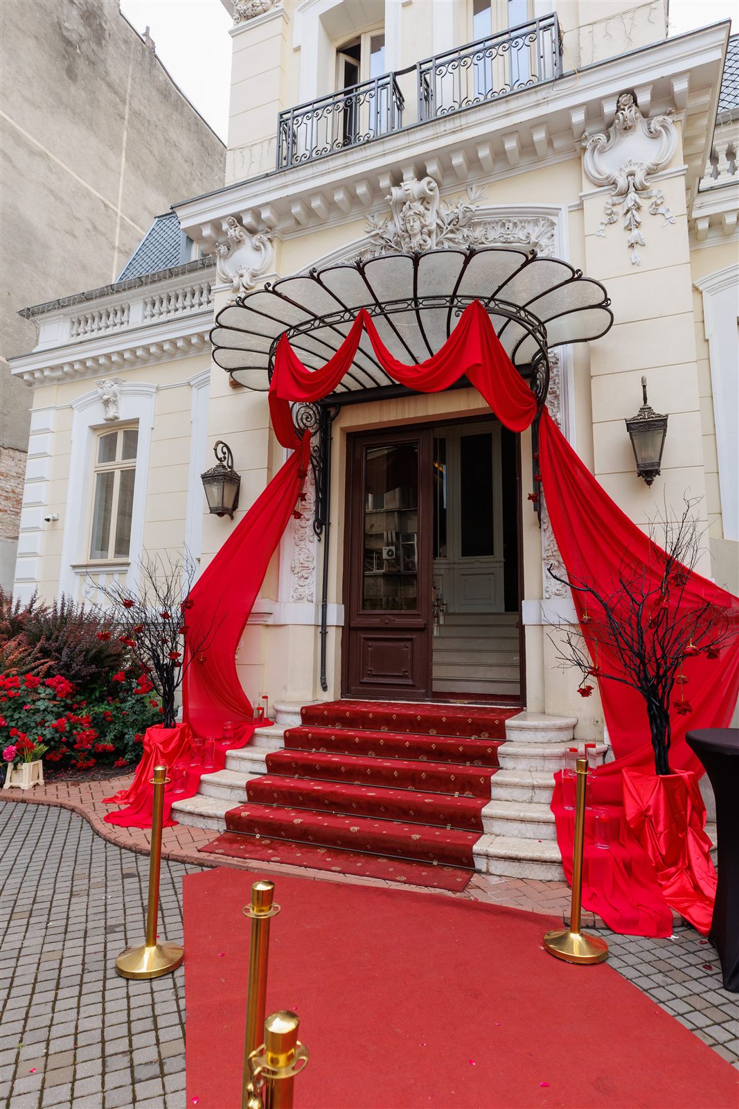 Intrarea Palatului cu covor roșu, drapaje roșii și felinare — primire tematică Dracula la Palatul Noblesse