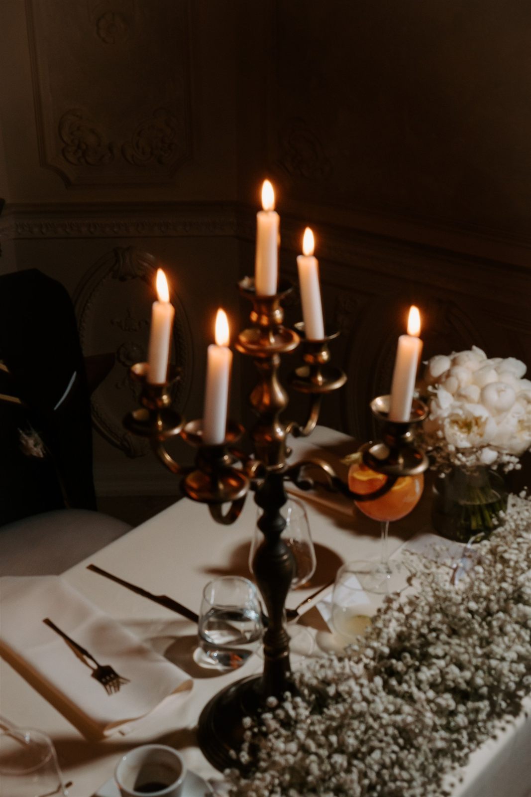 Candelabru, lumânări și floarea-miresei — atmosferă de seară la nuntă