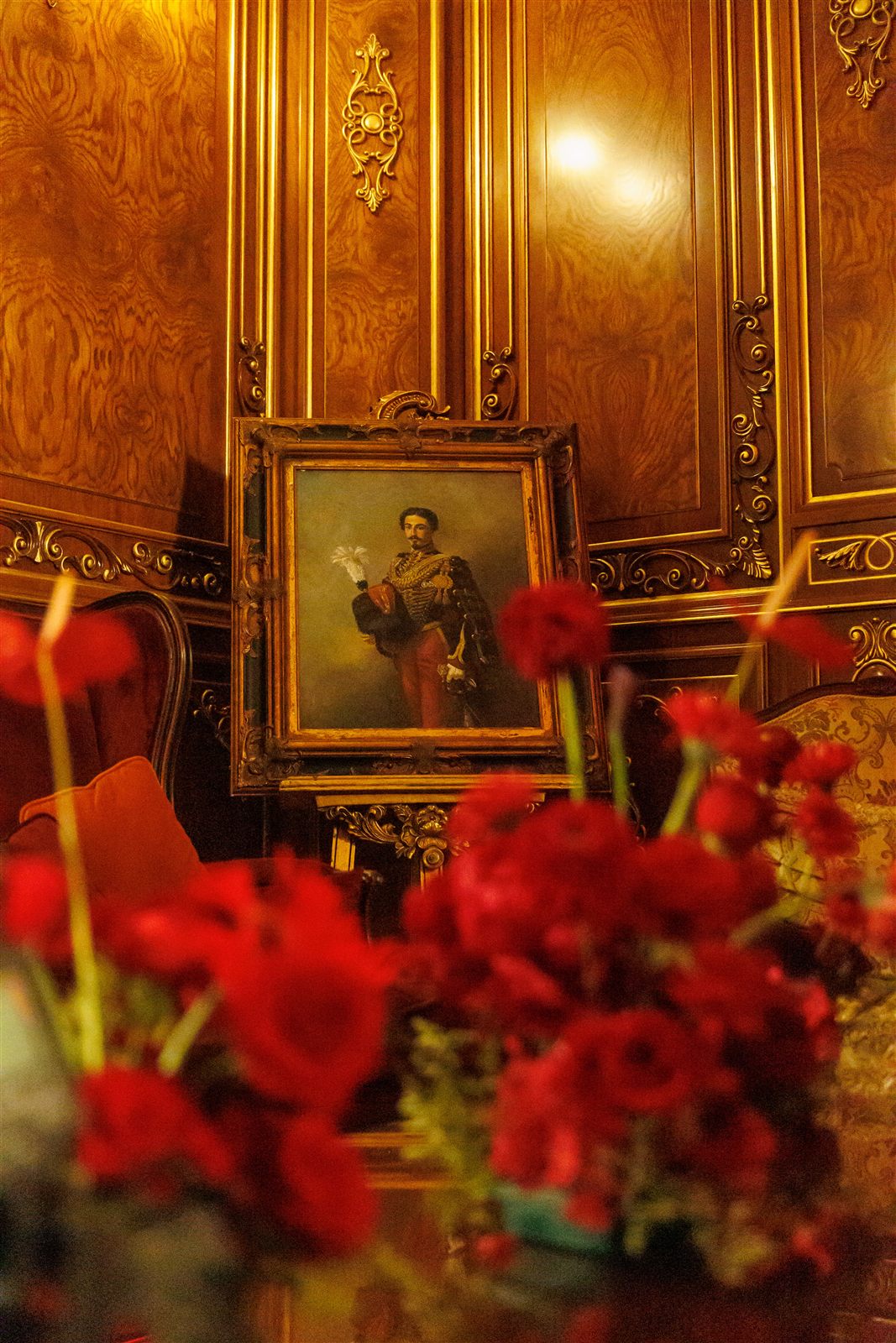 Portret în ramă aurită cu trandafiri roșii într-un salon — detaliu de atmosferă la Palatul Noblesse
