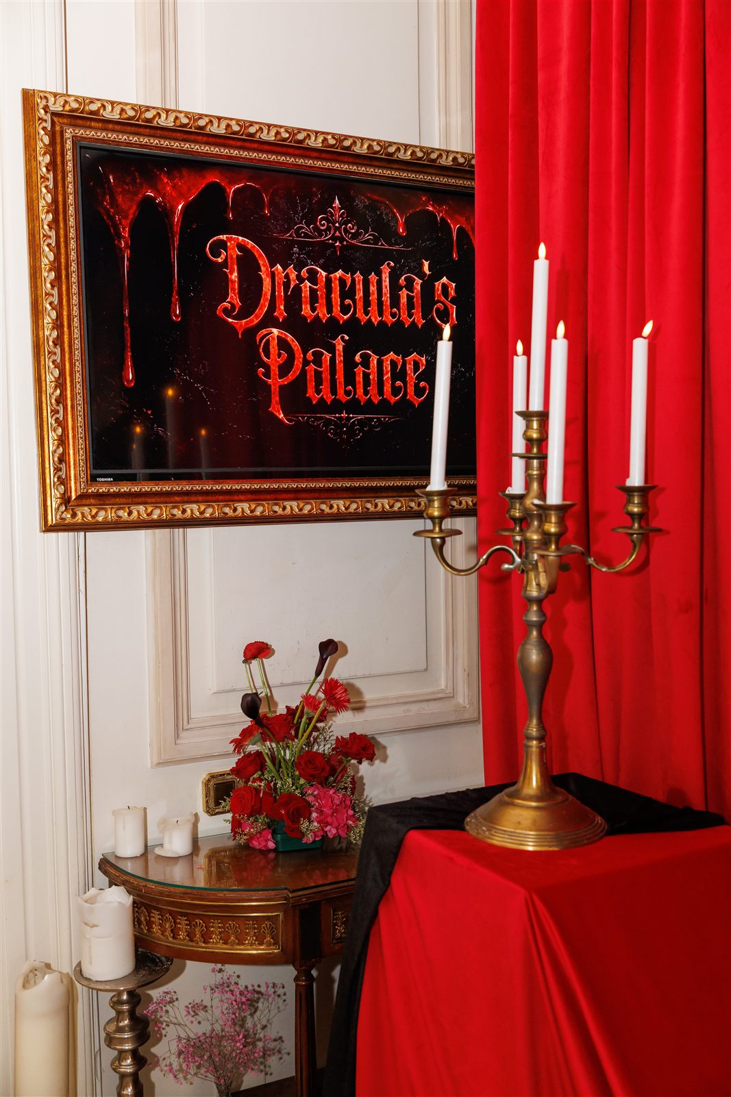 Panou „Dracula's Palace" cu trandafiri roșii și candelabru — branding vizual de eveniment tematic