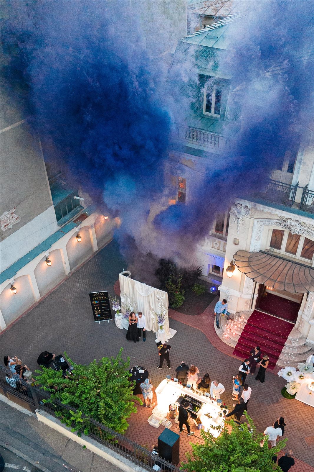 Vedere aeriana a curtii Palatului Noblesse cu fum colorat mov in timpul unui eveniment