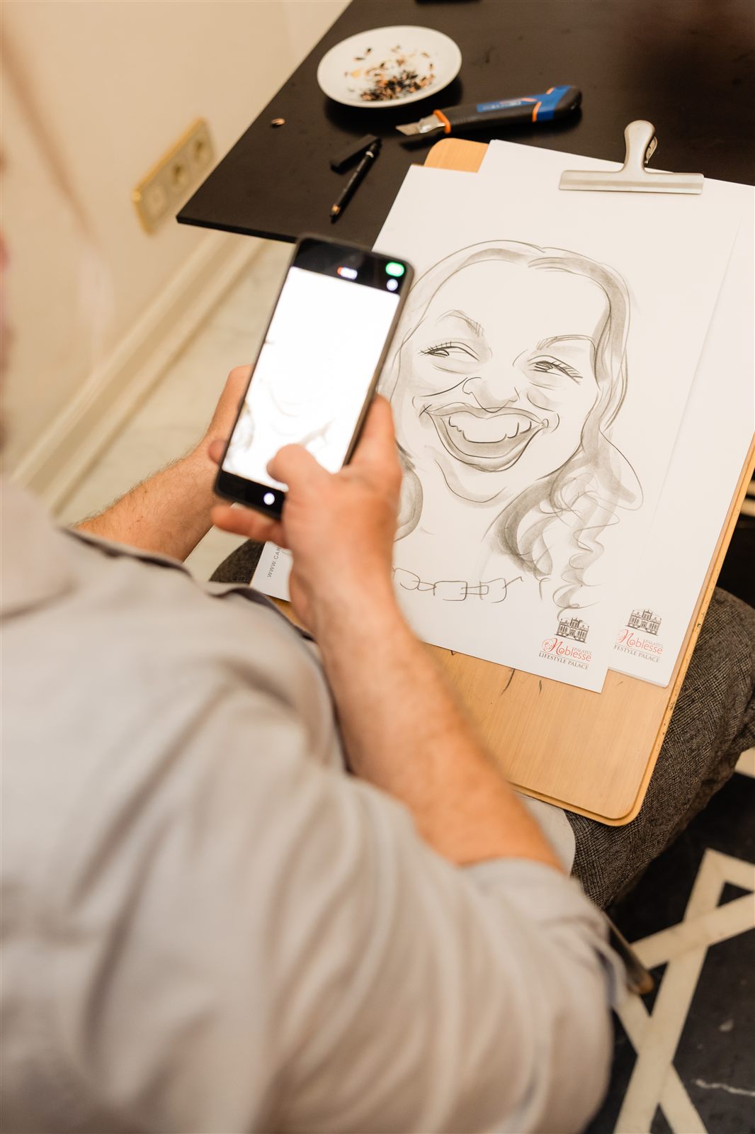 Mâna caricaturistului desenând o caricatură — detaliu de la un eveniment la Palatul Noblesse