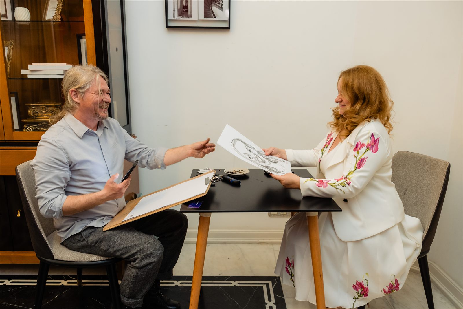 Momentul înmânării caricaturii către un invitat — divertisment la Palatul Noblesse